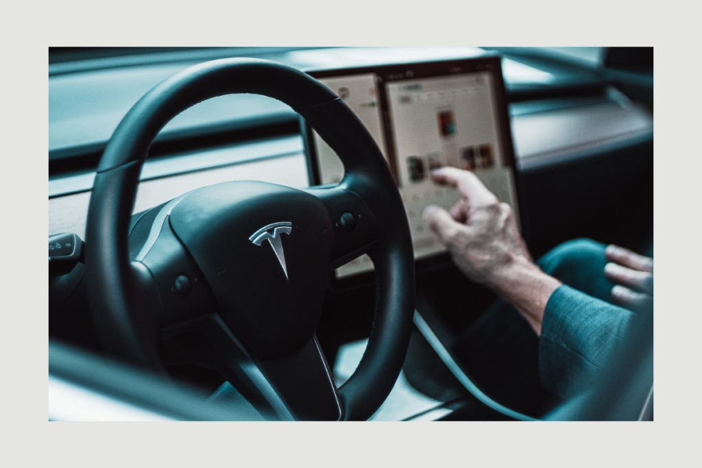 A man driving a Tesla Car